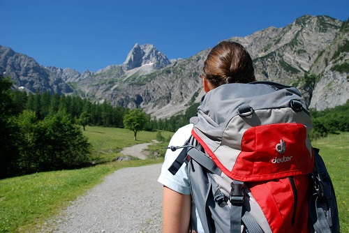 Frau mit Rucksack vor Bergpanorama