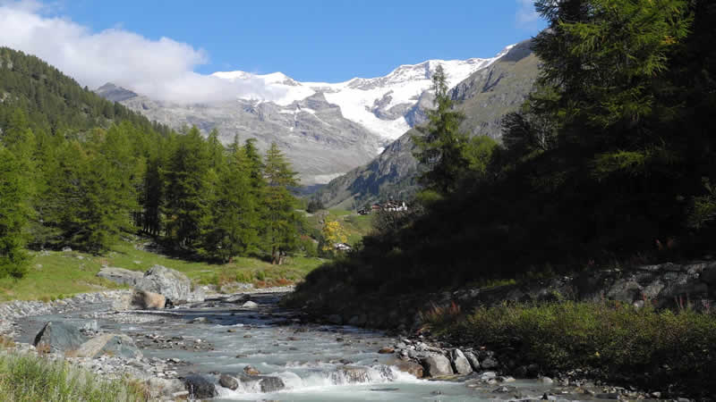 Bergpanorama mit schneebedecktem Monte Rosa und Gebirgsfluss