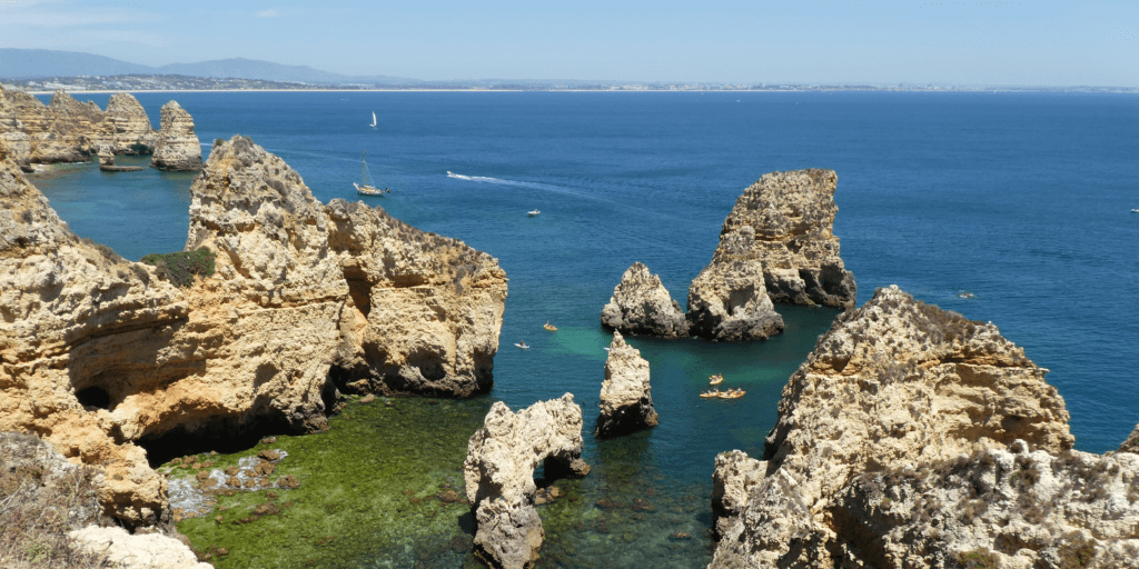 Küste mit Felsen und türkisblaues Wasser in der Algarve Portugal in Lagos