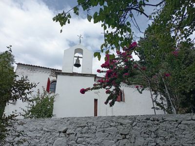 Weiße Kirche mit Bougainvilleblüten im Vordergrund