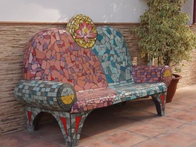 Mit Mosaikfliesen verzierte Sitzbank im Garten