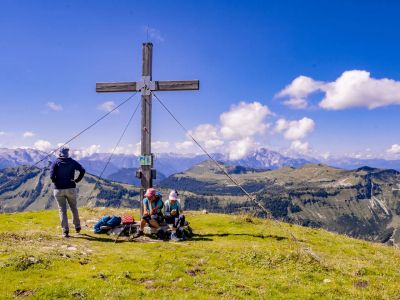 Familienwandern Pause am Gipfelkreuz